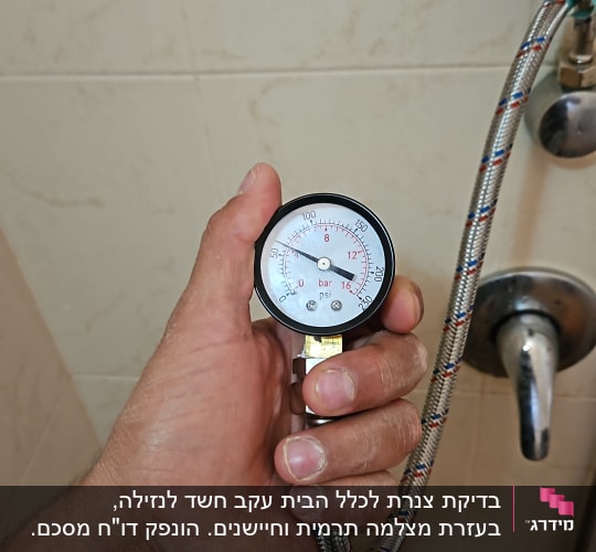 מד לחץ מים מחובר לצינור במקלחת